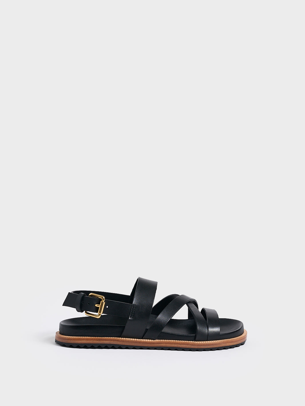 Profile view of a black leather molded footbed slide sandal with an adjustable back strap.