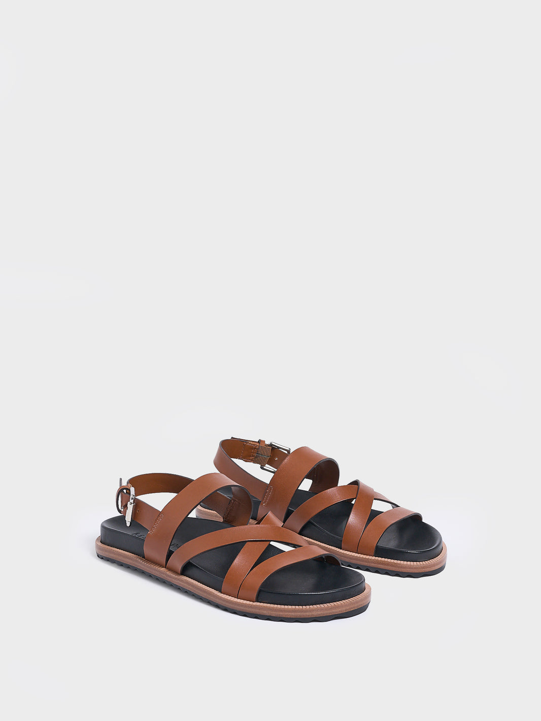 Angle view of a pair of chestnut leather molded footbed slide sandals with an adjustable back strap.