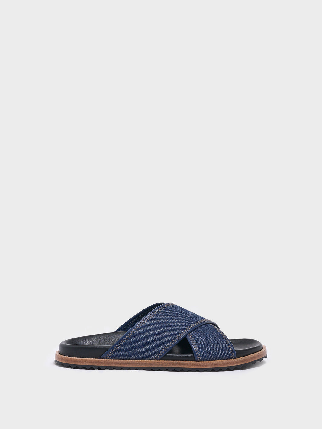 Profile view of a navy denim molded footbed slide sandal.