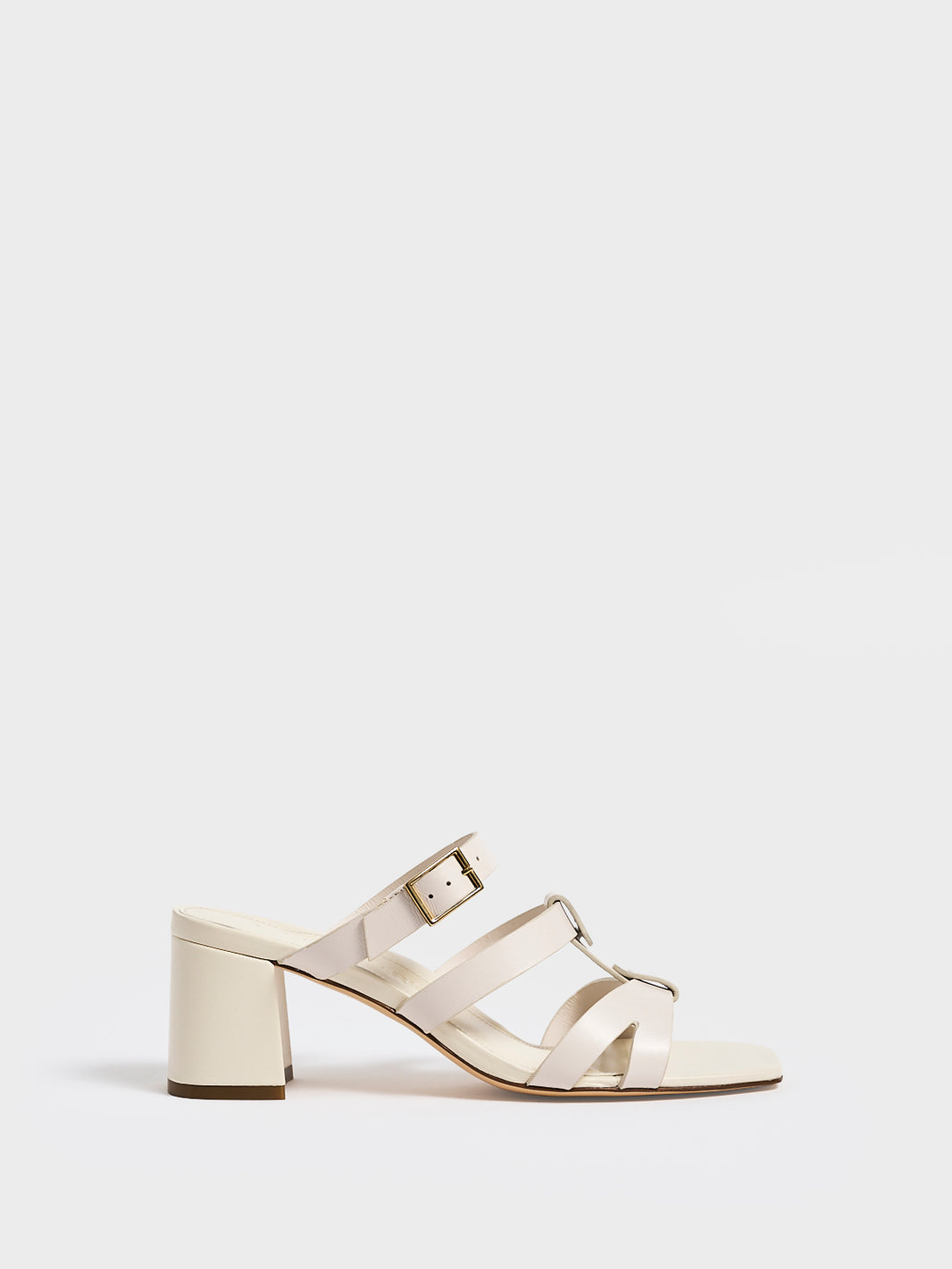 Profile view of an ivory leather gladiator block heel sandal.