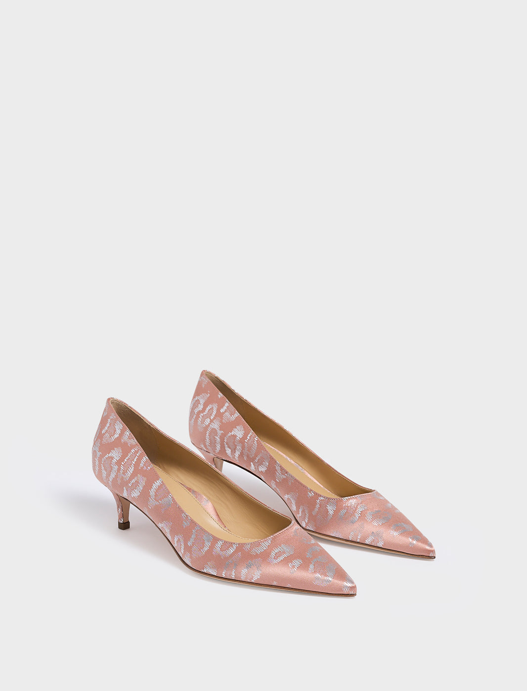 Angle view of a pair of blush leopard silk kitten stiletto heel pumps with a pointed toe.