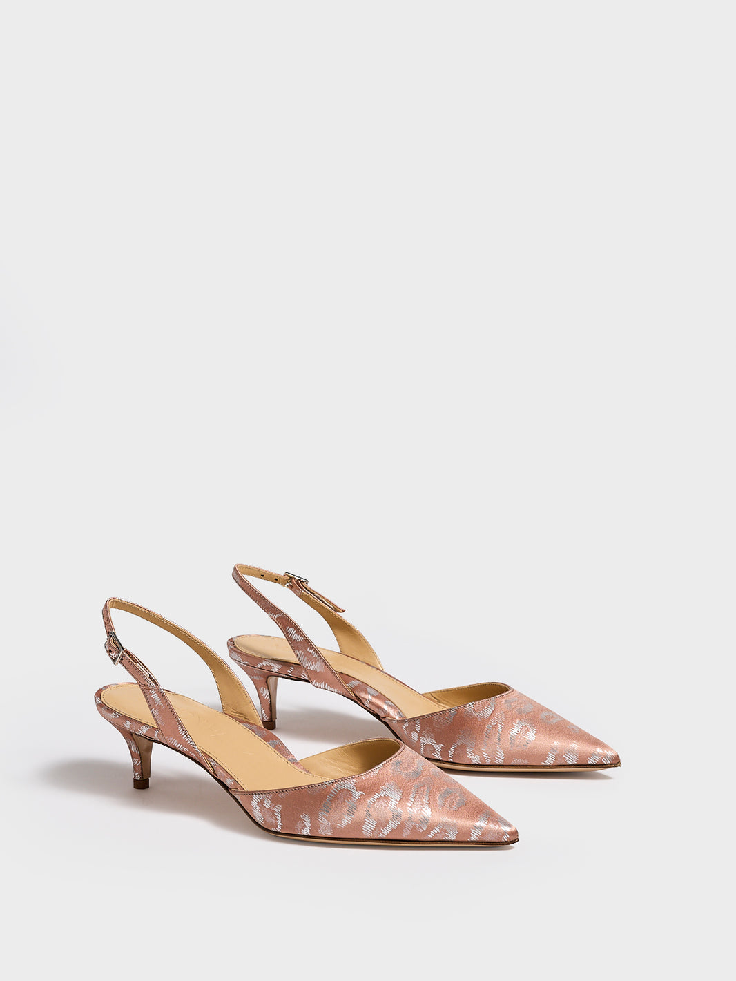 Angle view of a pair of blush leopard silk slingback kitten heels with a pointed toe