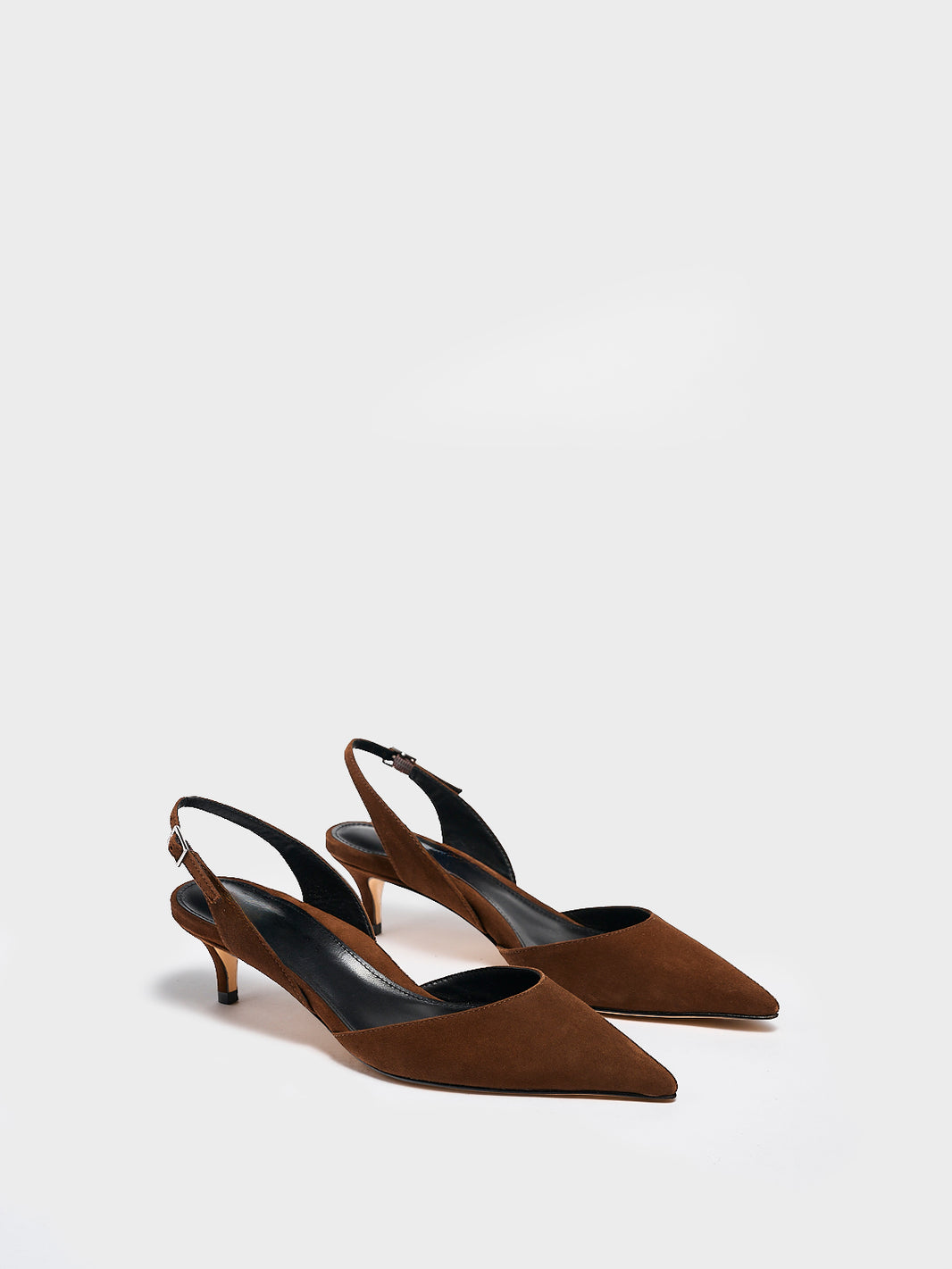Profile view of a chocolate suede slingback  kitten heel with a pointed toe