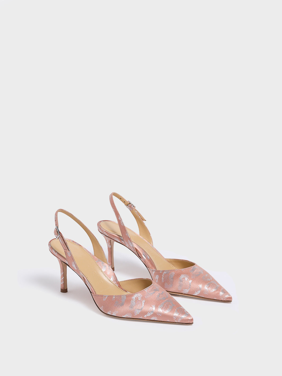 Angle view of a pair of blush leopard silk slingback heels with a pointed toe.