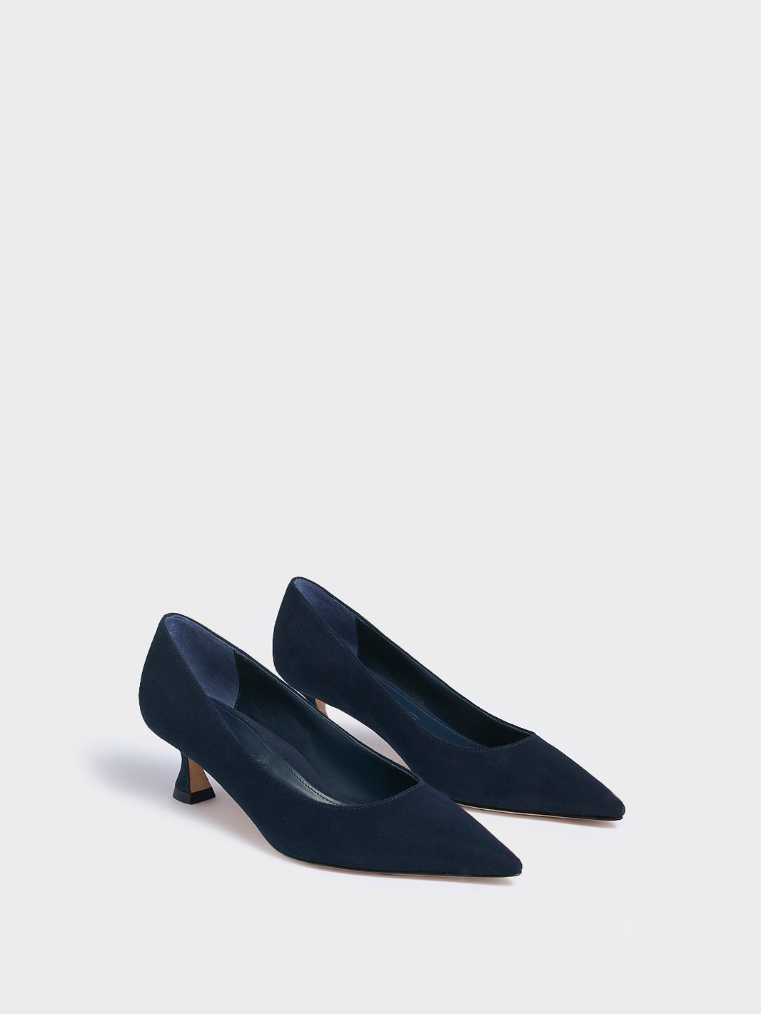 Angle view of a pair of navy suede flared kitten heel pumps with a pointed toe.