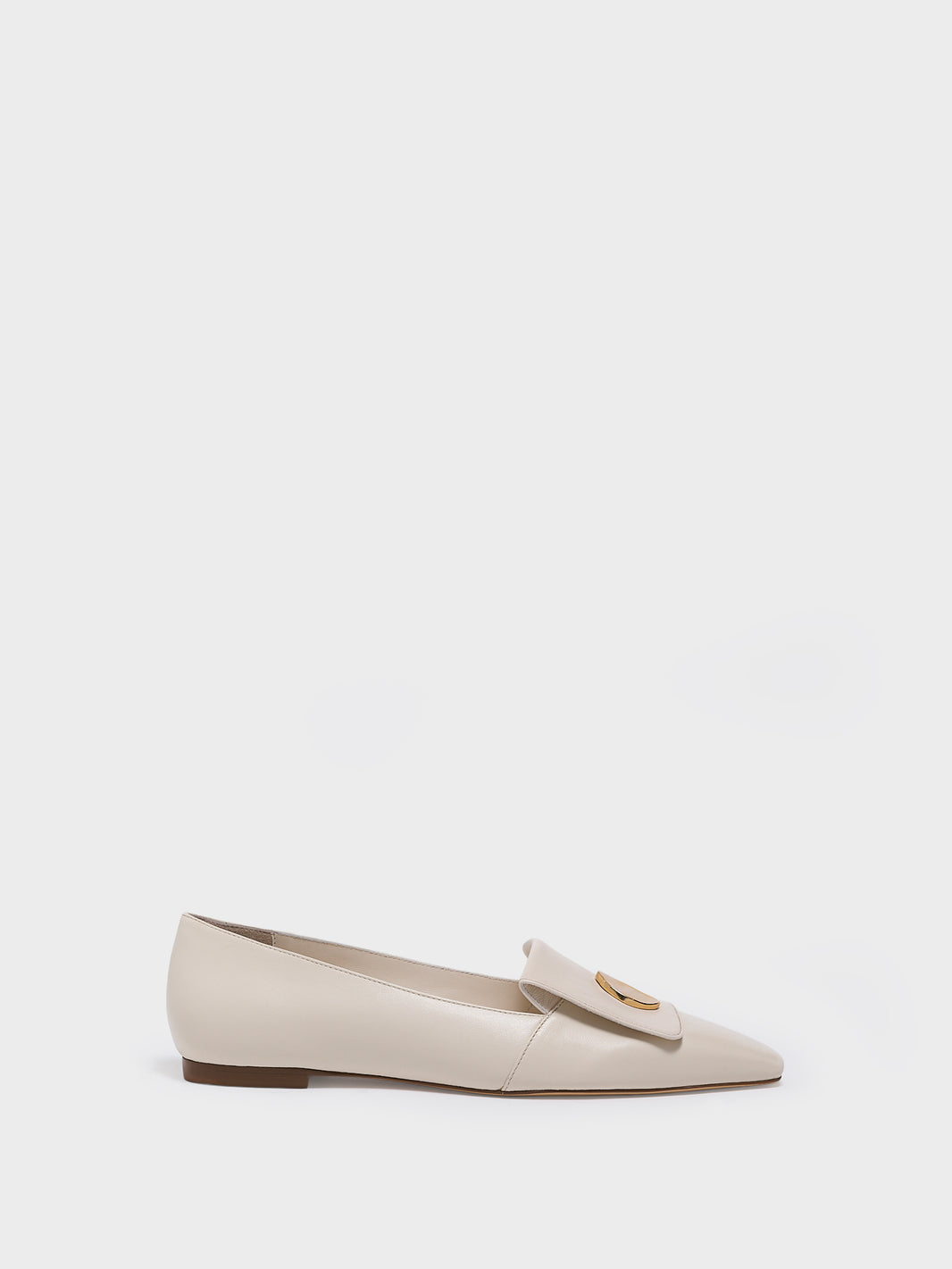 Profile view of a ivory leather  flat loafer with a  gold hardware detail and squared toe. 