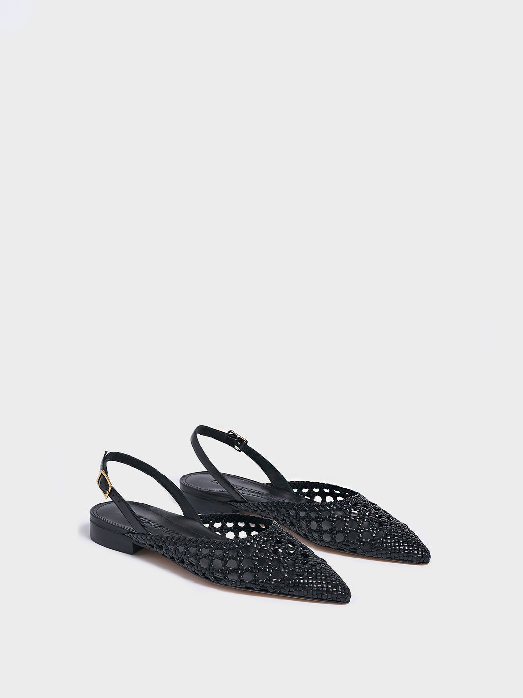Angle view of a pair of black braided leather slingback flats with a pointed toe