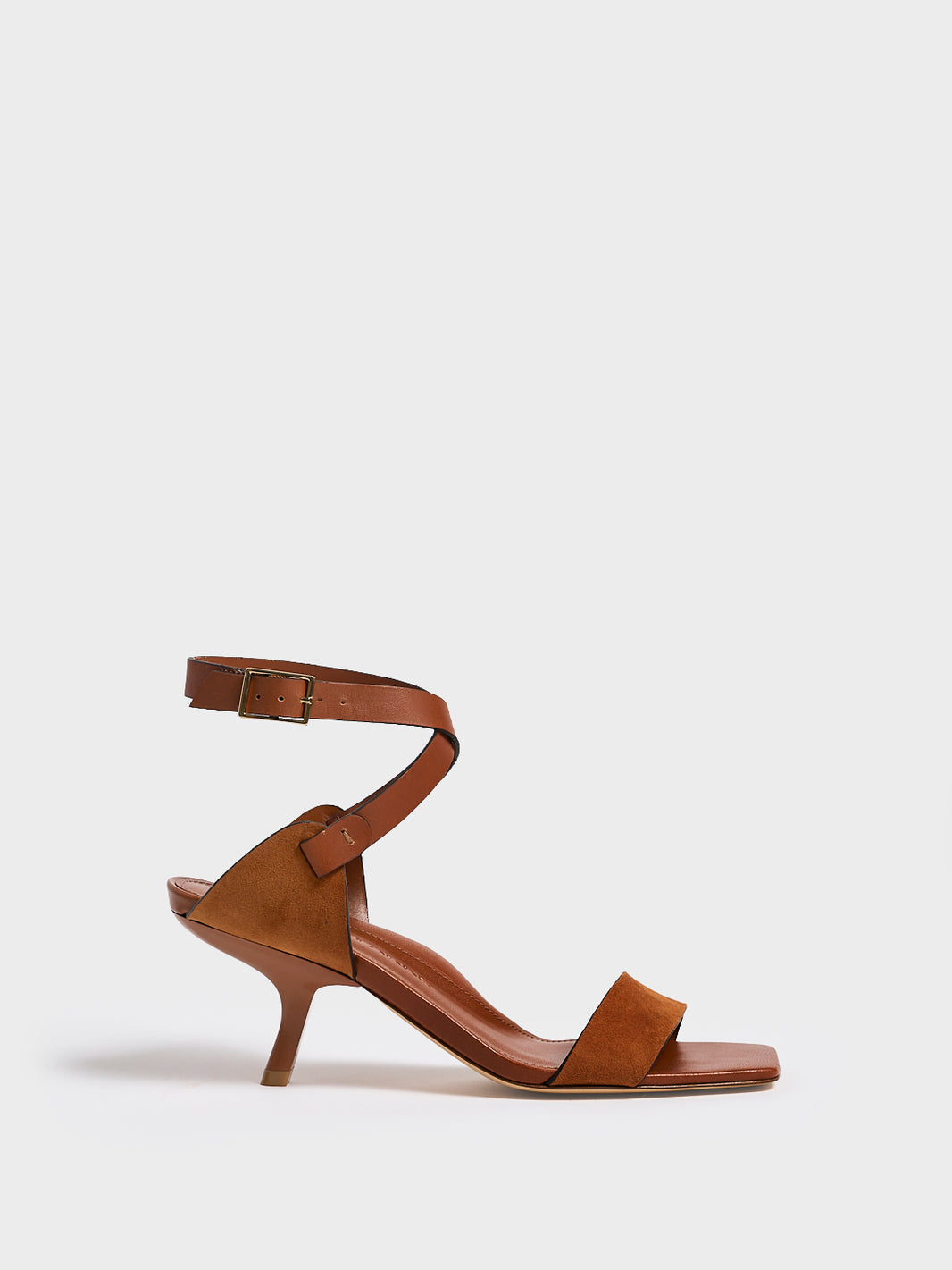 Profile view of a chestnut leather and suede high heel sandal with a sculptural design and adjustable ankle strap. 